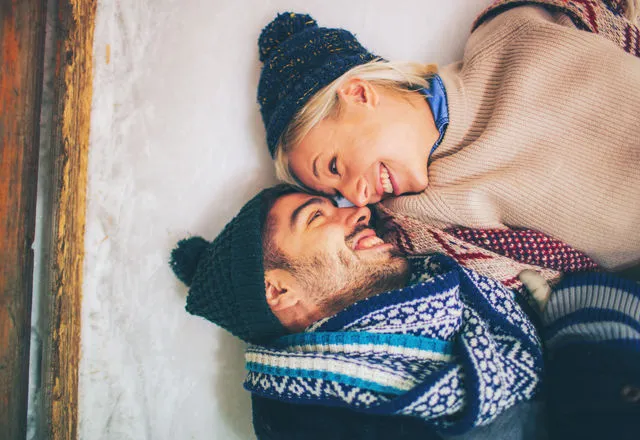 雪の上で寝そべるカップル